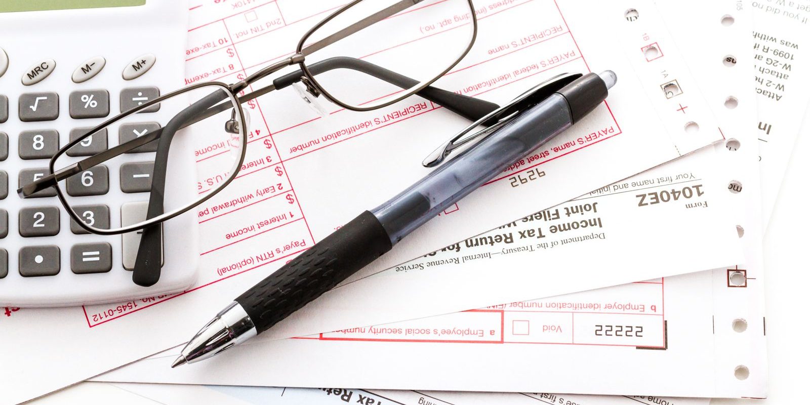 Calculating numbers for income tax return with pen and calculato