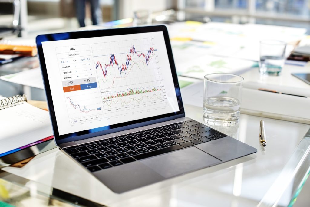 Laptop z wykresami finansowymi na biurku – analiza finansowa, wyniki i inwestycje