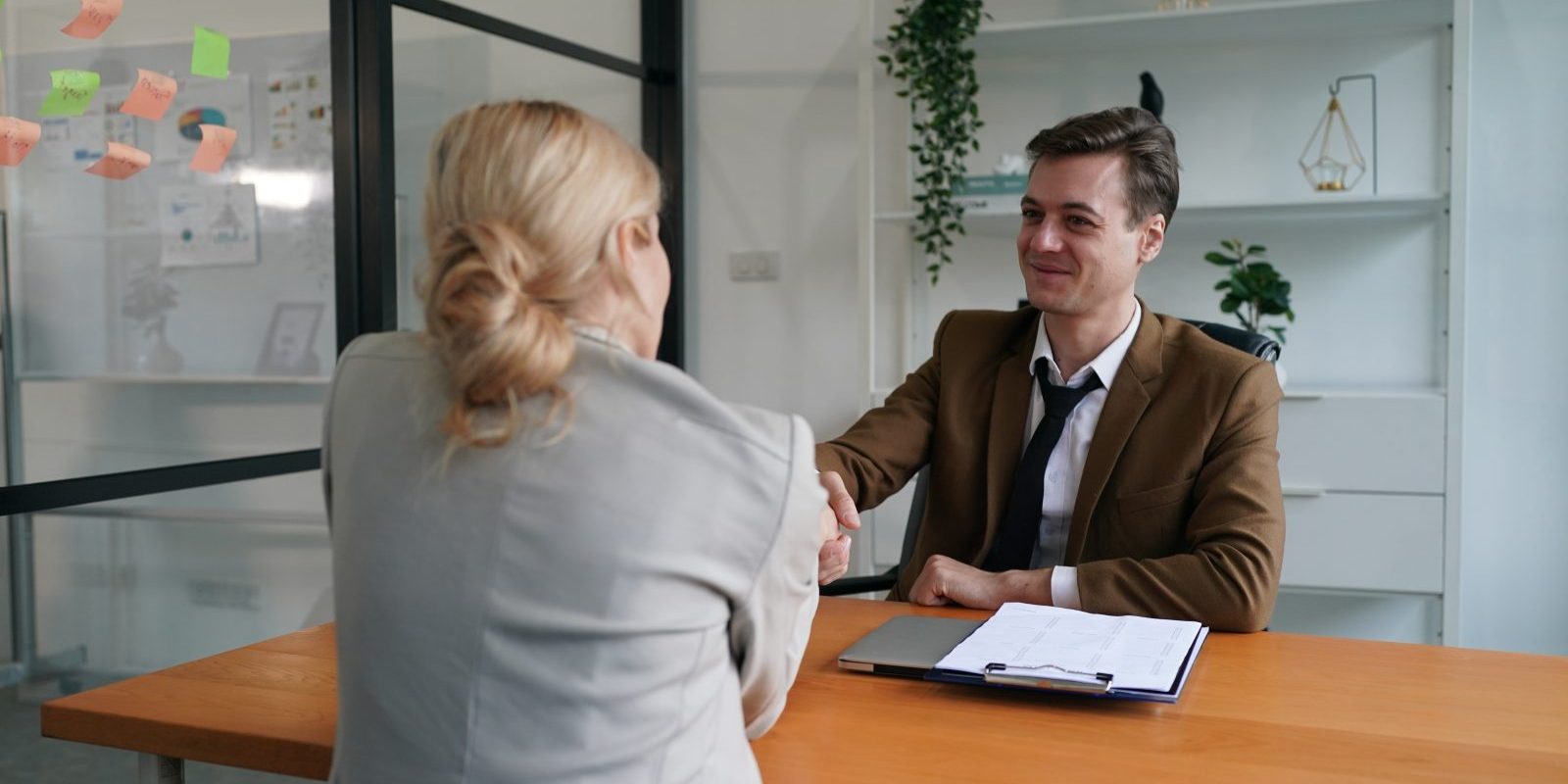 Uścisk dłoni – umowa z biurem rachunkowym Uścisk dłoni przy biurku z umową – rozpoczęcie współpracy z biurem rachunkowym